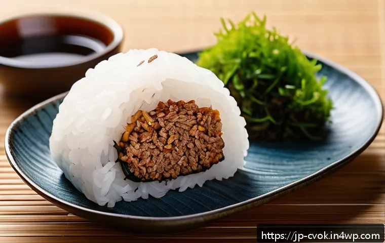 대체 단백질 요리법으로 만드는 영양 만점 주먹밥 - A close-up of a neatly shaped onigiri rice ball filled and mixed with textured soy meat, seasoned wi...